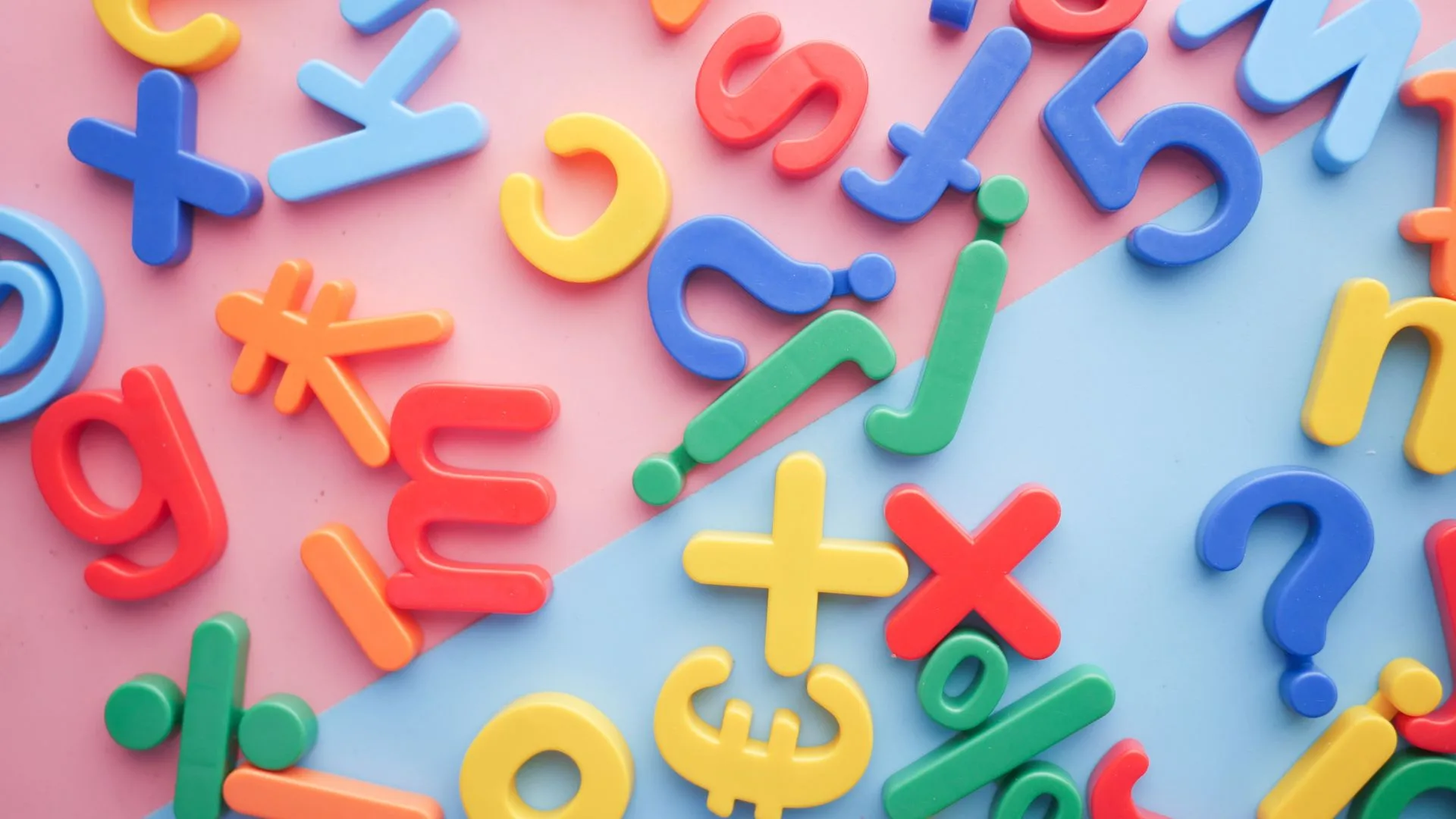Colourful letters and symbols scattered across a pink and blue background, representing literacy and communication.